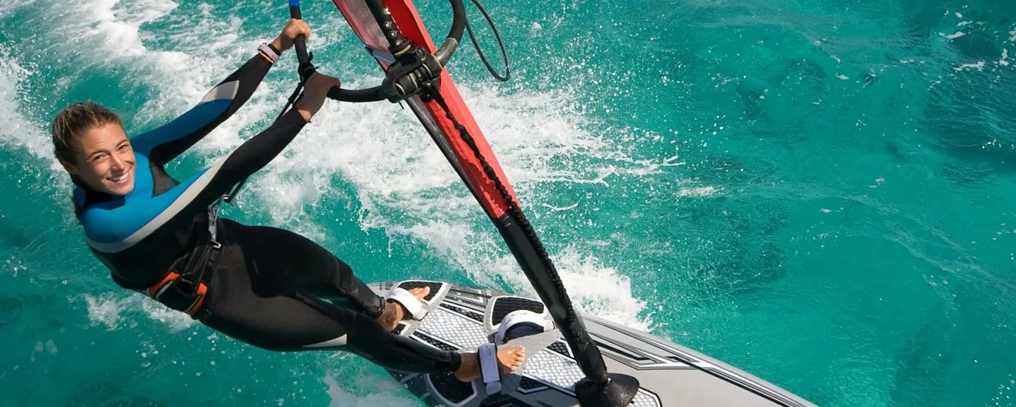 Girl in wetsuit Windsurfing