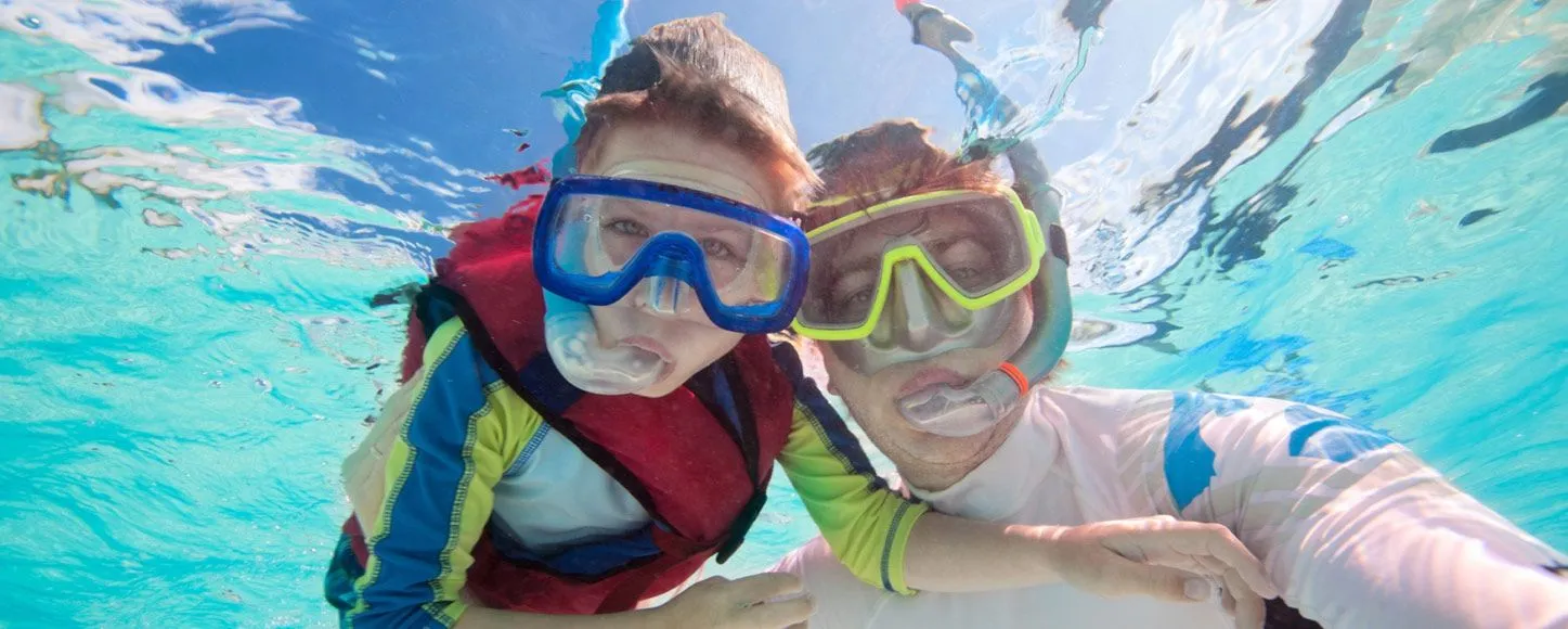 Father and sun snorkeling underwater